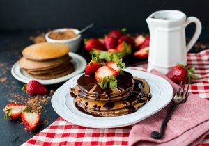 pancake with chocolate syrup on ceramic plate